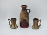 three vases sitting next to each other on a white surface