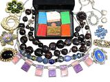a black case filled with assorted jewelry on a white surface
