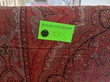 a red and black blanket with a green label on it