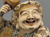 a figurine of a laughing man holding a hammer in his hand