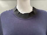 a mannequin wearing a purple shirt with a black collar