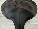 une image représentant une selle en cuir ornée de deux ailes