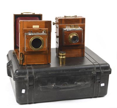 two old cameras sitting on top of a piece of luggage