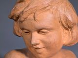 statue of a young boy holding a bird in his hand