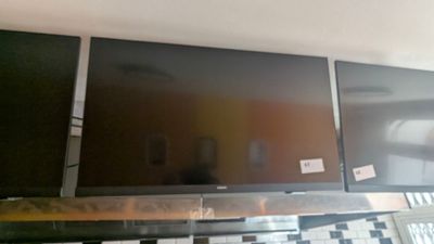 three flat screen televisions sitting on top of a shelf in a room