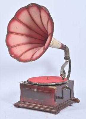 un vieux gramophone muni d'un pavillon rouge, posé sur un socle en bois