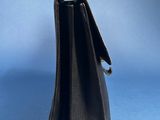 a black leather purse with a silver clasp on a blue background