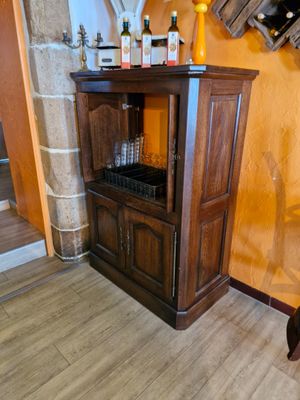 une armoire en bois surmontée d'un casier à bouteilles