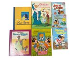 several children ' s books are lined up on a white surface