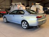 a silver car parked in a garage with a crane in the background