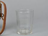 a glass and a small wooden clock on a table
