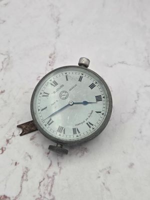 une horloge en argent ornée de chiffres romains, posée sur un socle en marbre