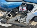 un gros plan d'une moto bleue garée sur un parking