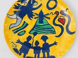 une assiette jaune sur laquelle est représentée une sorcière et deux enfants