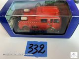 un camion de pompiers rouge dans une boîte bleue posée sur une table
