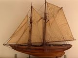 une maquette en bois d'un voilier posée sur une étagère