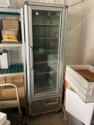 a refrigerator that is next to a stack of boxes in a room