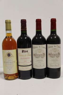 quatre bouteilles de vin sont alignées sur une surface blanche