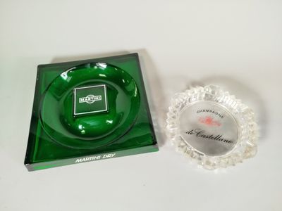 un cendrier en verre vert et un cendrier en verre transparent posés sur une table blanche