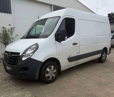 la photo d'une camionnette blanche garée devant un bâtiment
