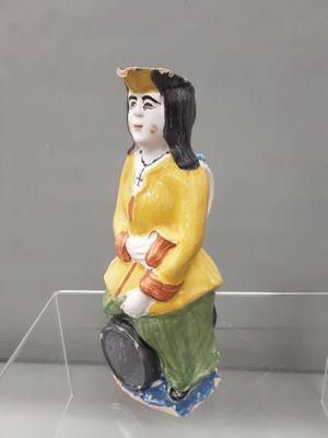 a figurine of a woman sitting on a glass shelf