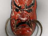 a red mask with long hair on a white surface