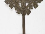 an image of a metal cross hanging on a white wall