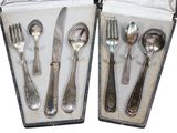 deux sets d'argenterie dans un coffret sur une table