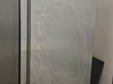 a stainless steel refrigerator in the corner of a room