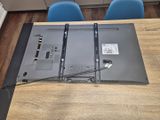 a laptop sitting on top of a wooden table with blue chairs