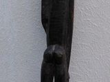 a wooden statue of a man standing on a wooden stand