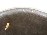 a close up view of a metal plate with a brown patt on it