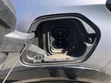 an electric car plugged in to a charging station on the side of the road