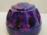 a blue helmet with pink dots on it sitting on a table