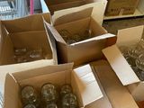 plusieurs cartons remplis de verres à vin vides posés sur une table