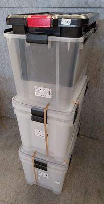 three plastic storage boxes stacked on top of each other on the floor