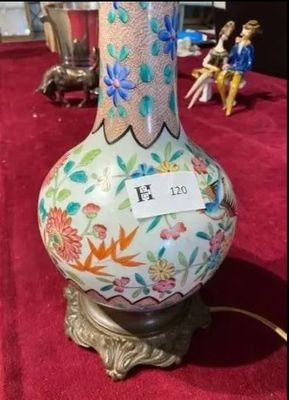 un vase posé sur une table, sur laquelle se trouve une étiquette avec un nom