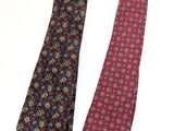 two ties with different designs on them on a white surface