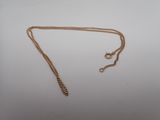 un collier en or auquel est attachée une chaîne