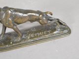 bronze statue of a dog running on a plaque with a nameplate