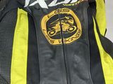 a yellow and black motorcycle jacket on a white couch