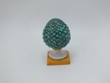 un gros plan d'une figurine représentant un ananas posée sur un socle en bois