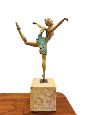 statue of a woman in a blue dress is standing on a marble block