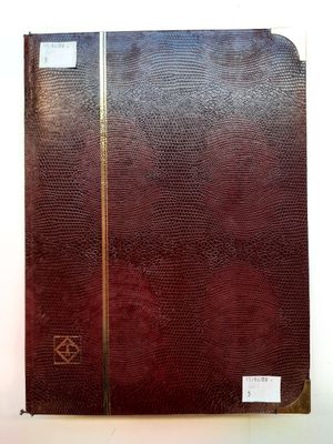 un vieux livre à la couverture marron et aux bords dorés, posé sur une surface blanche