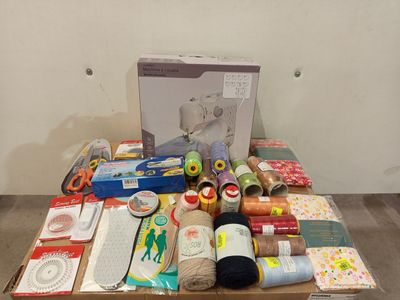 a box of sewing supplies on a table next to a sewing machine