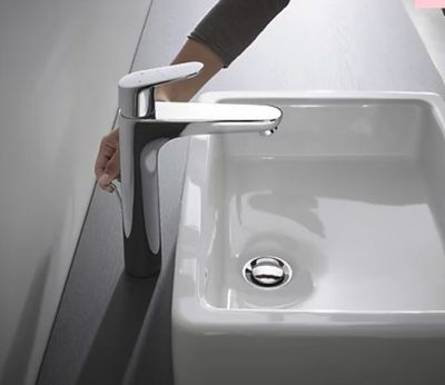 une personne qui se lave les mains dans le lavabo des toilettes