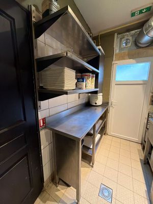 une porte noire dans une cuisine équipée d'un évier et d'une cuisinière