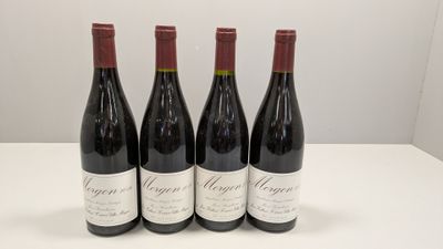 quatre bouteilles de vin rouge sont posées sur une table blanche