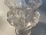 a glass vase sitting on a table with a blue background