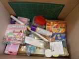 a cardboard box filled with craft supplies and crafting supplies